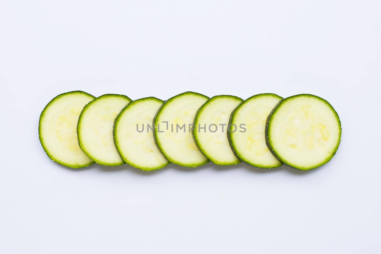 Zucchini slices on white background. Copy space
