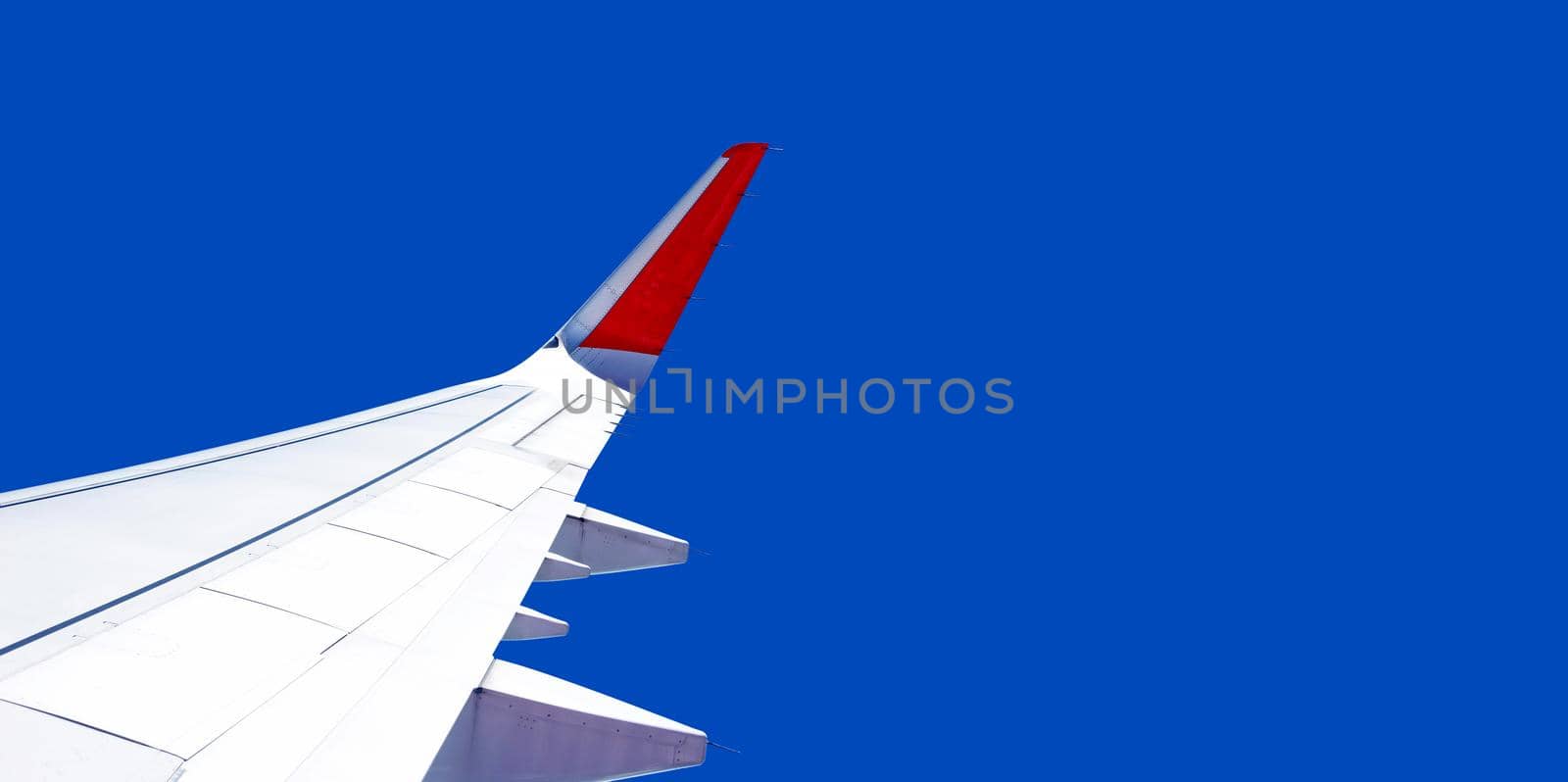 View of sky and wing of airplane from window by Bowonpat