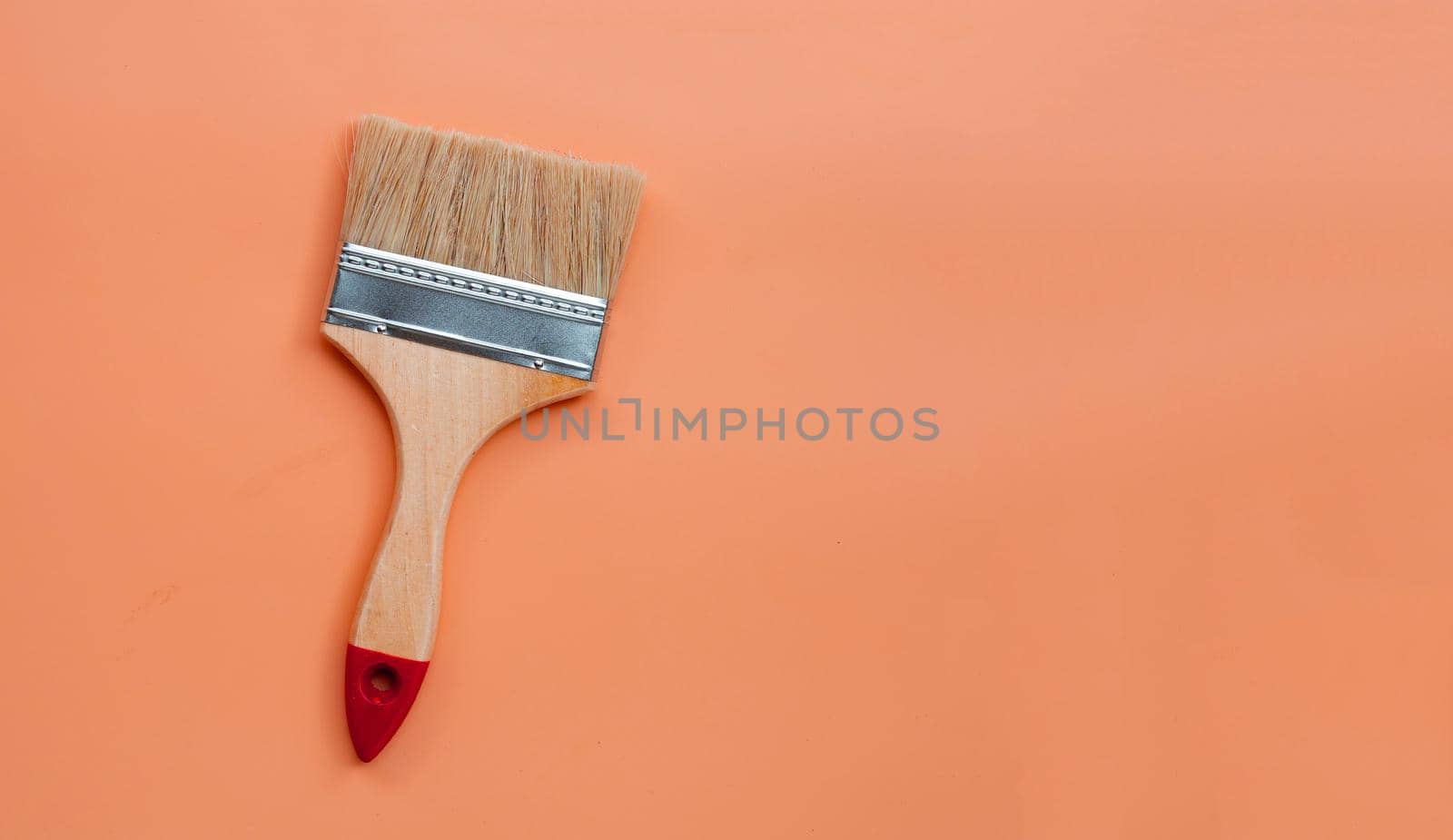 Paint brush on orange background. copy space