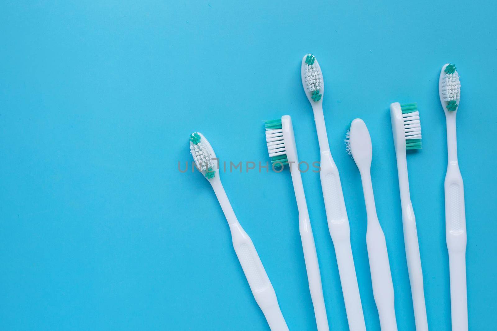 Toothbrushes on blue background. Top view by Bowonpat