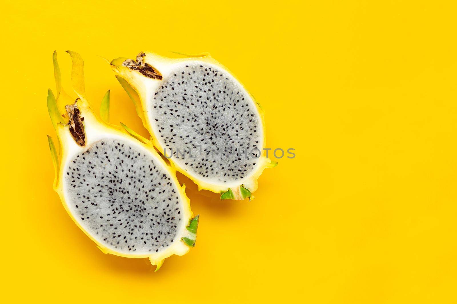 Yellow pitahaya or dragon fruit on yellow background. Copy space