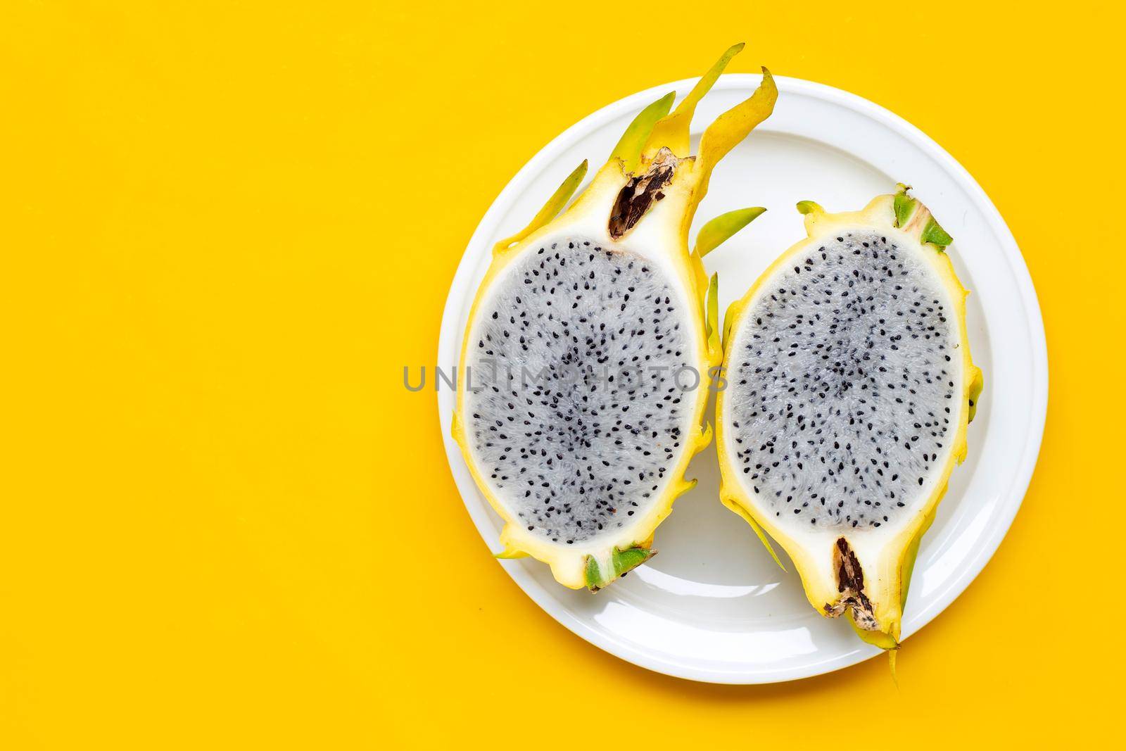 Yellow pitahaya or dragon fruit on yellow background. Copy space