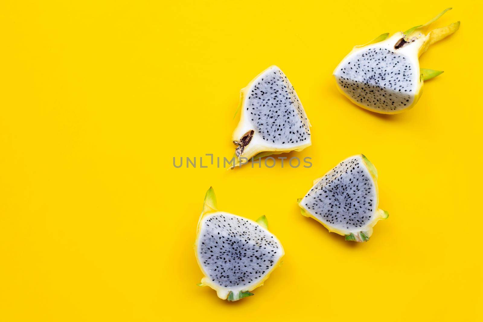Yellow pitahaya or dragon fruit on yellow background. Copy space