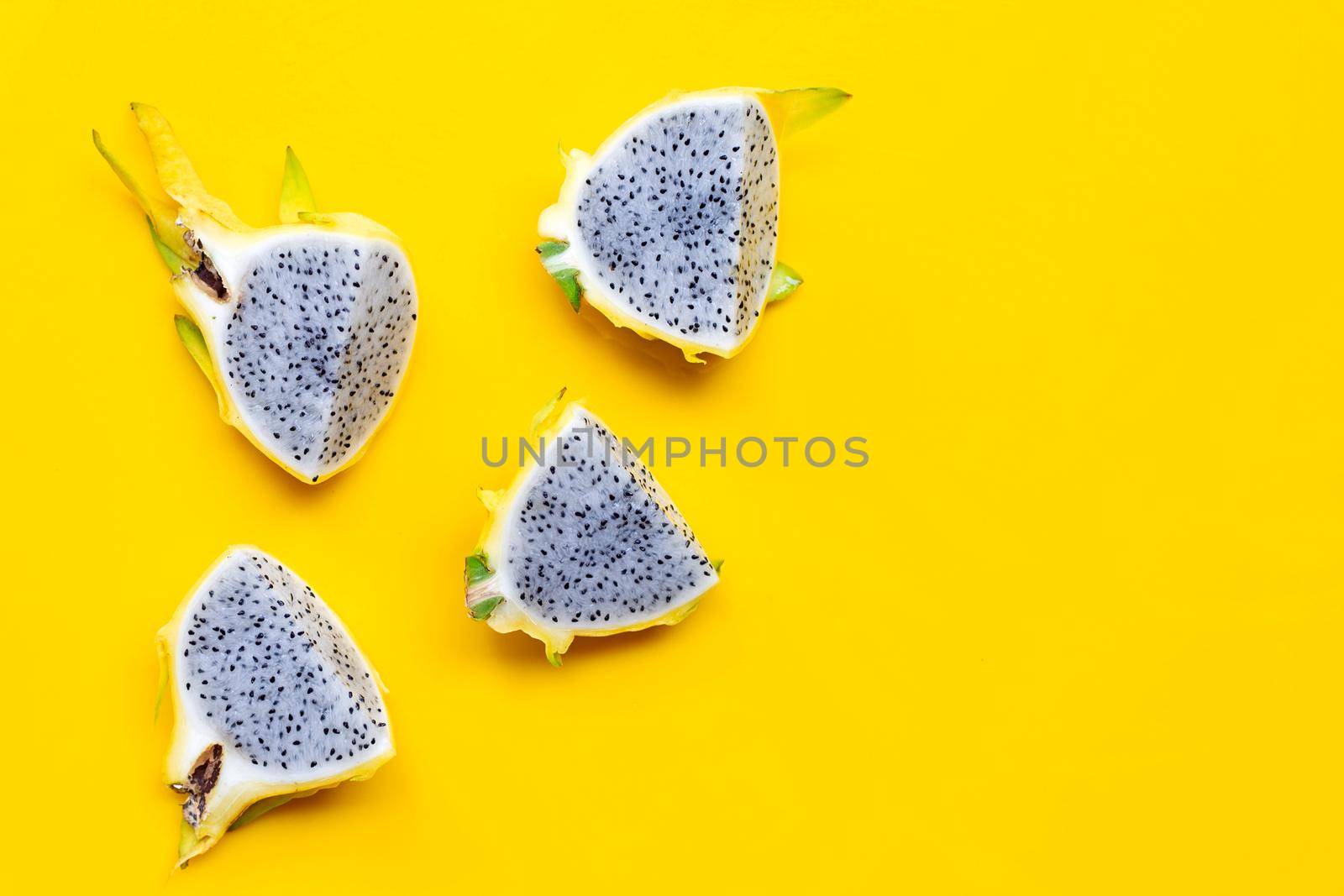 Yellow pitahaya or dragon fruit on yellow background. Copy space