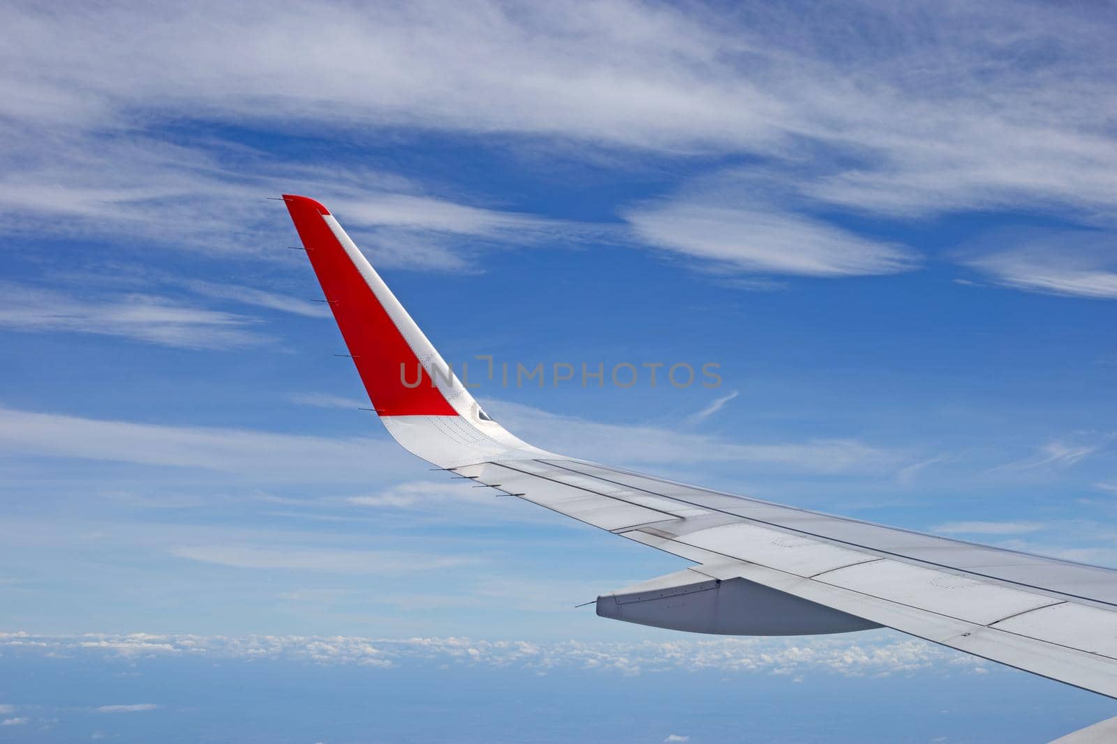 View of sky, cloud and wing from airplane window