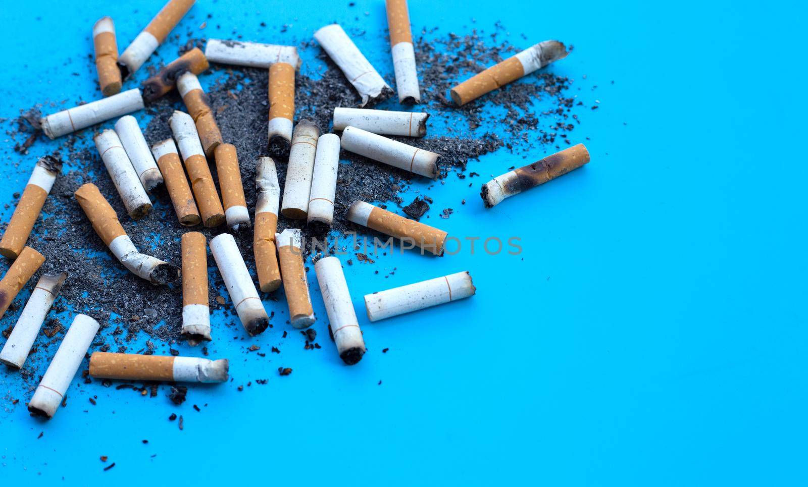 Dirty cigarette buds on blue background.