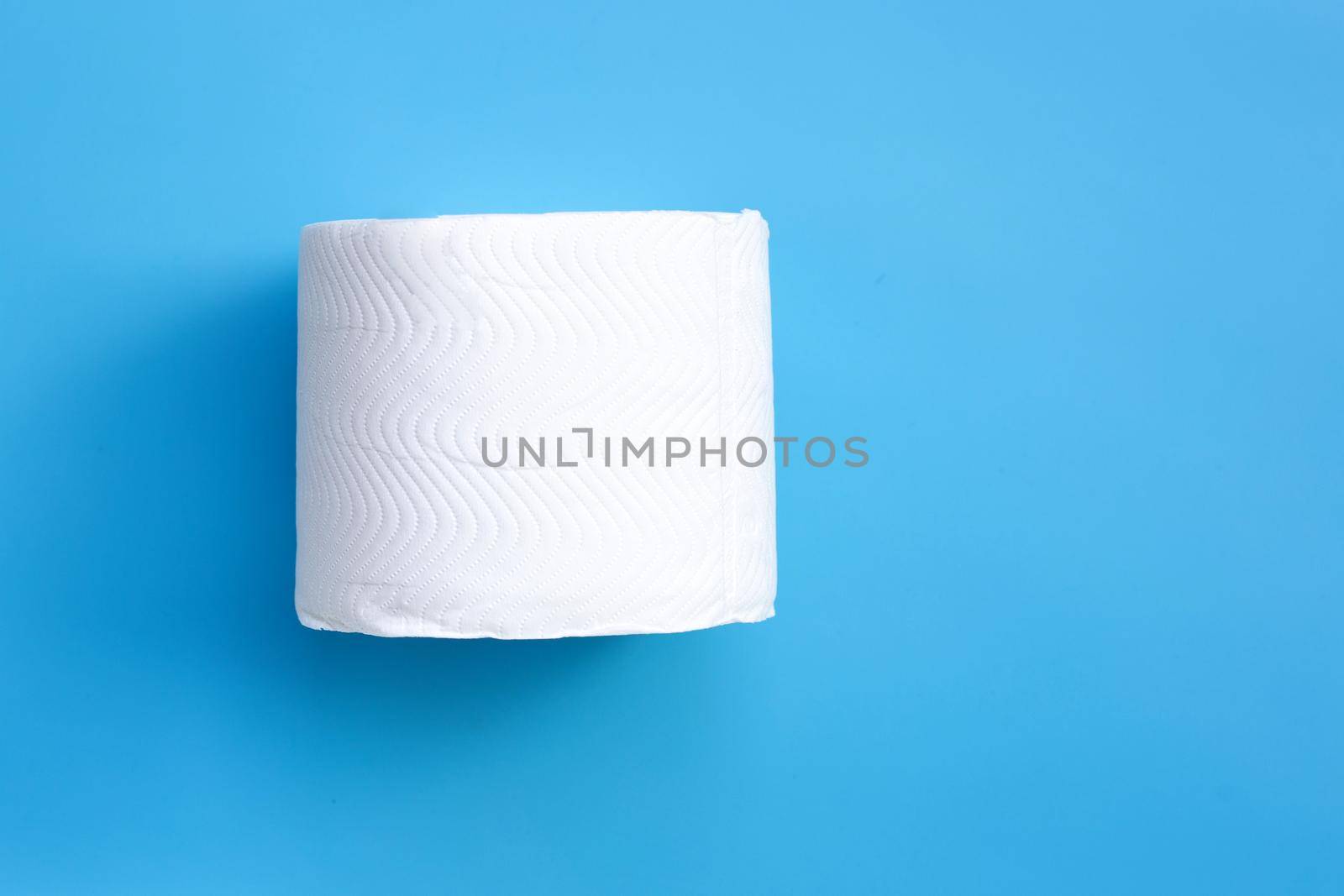 Toilet paper on blue background. Copy space