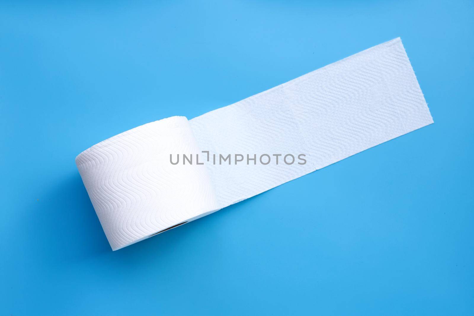 Toilet paper on blue background. Copy space