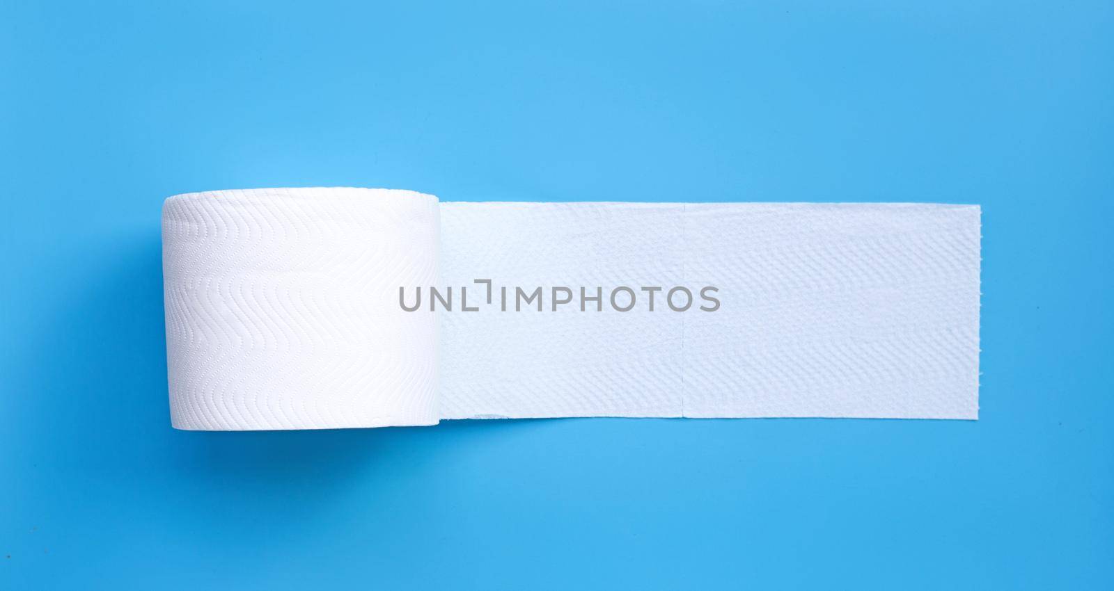 Toilet paper on blue background. Copy space