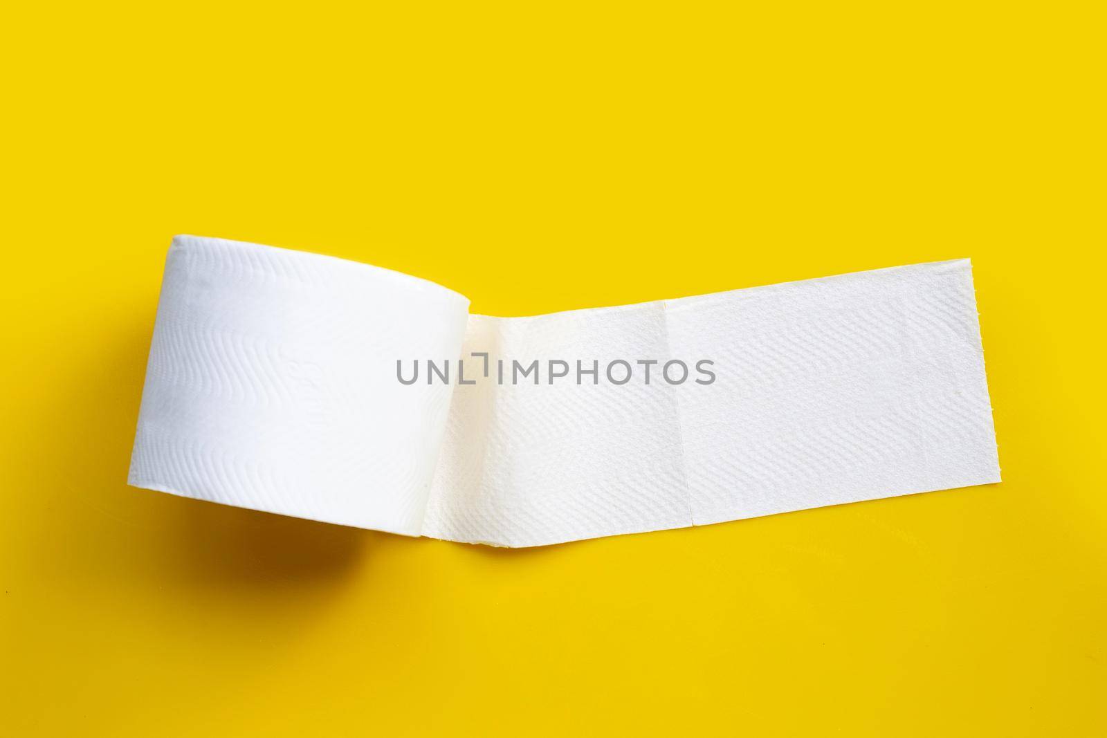 Toilet paper on yellow background. Copy space