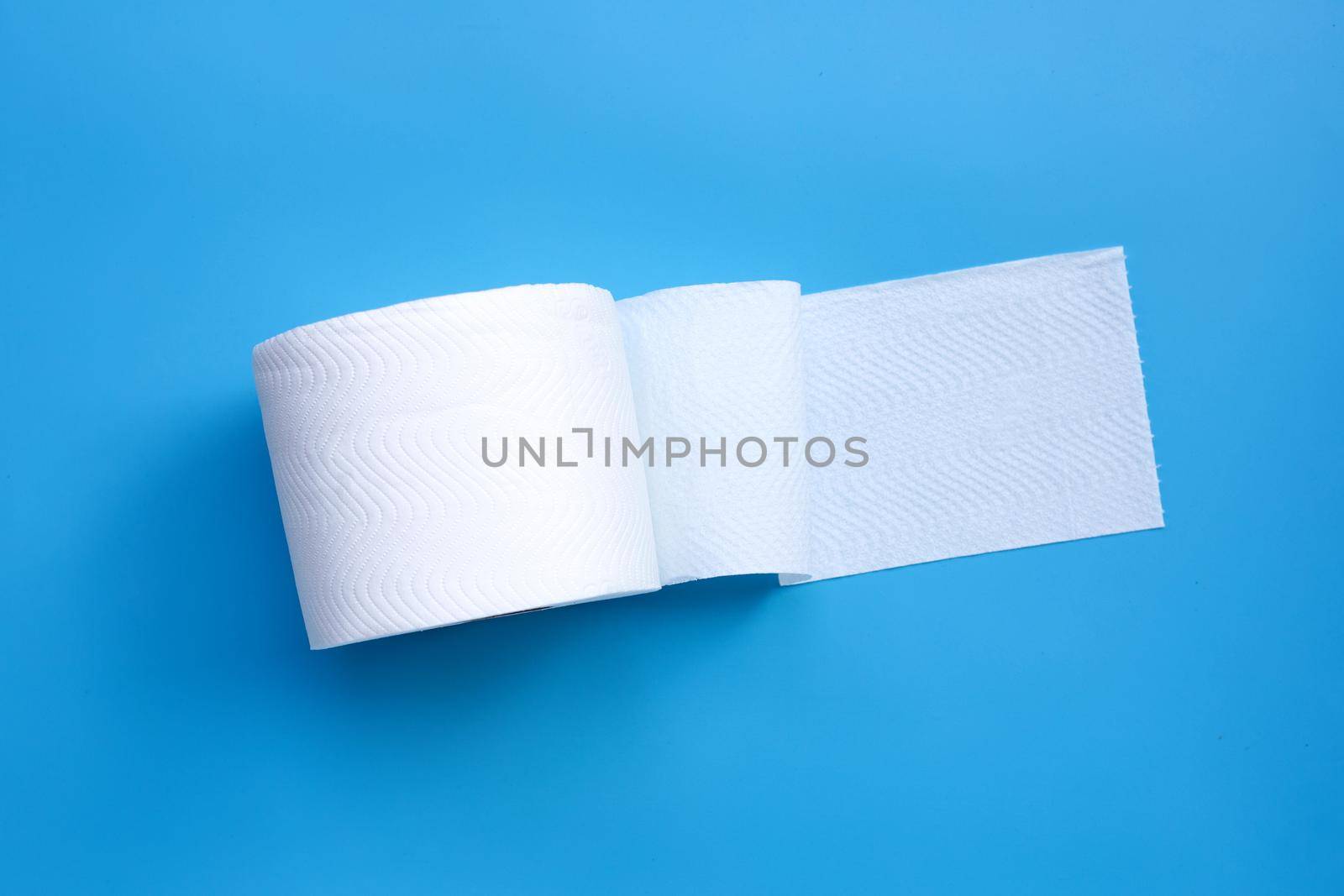 Toilet paper on blue background. Copy space