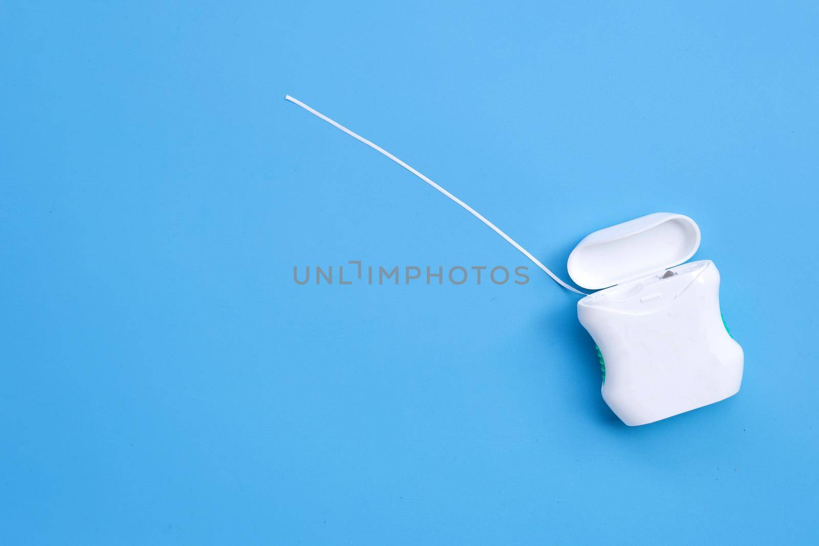 Dental floss on blue background. Copy space