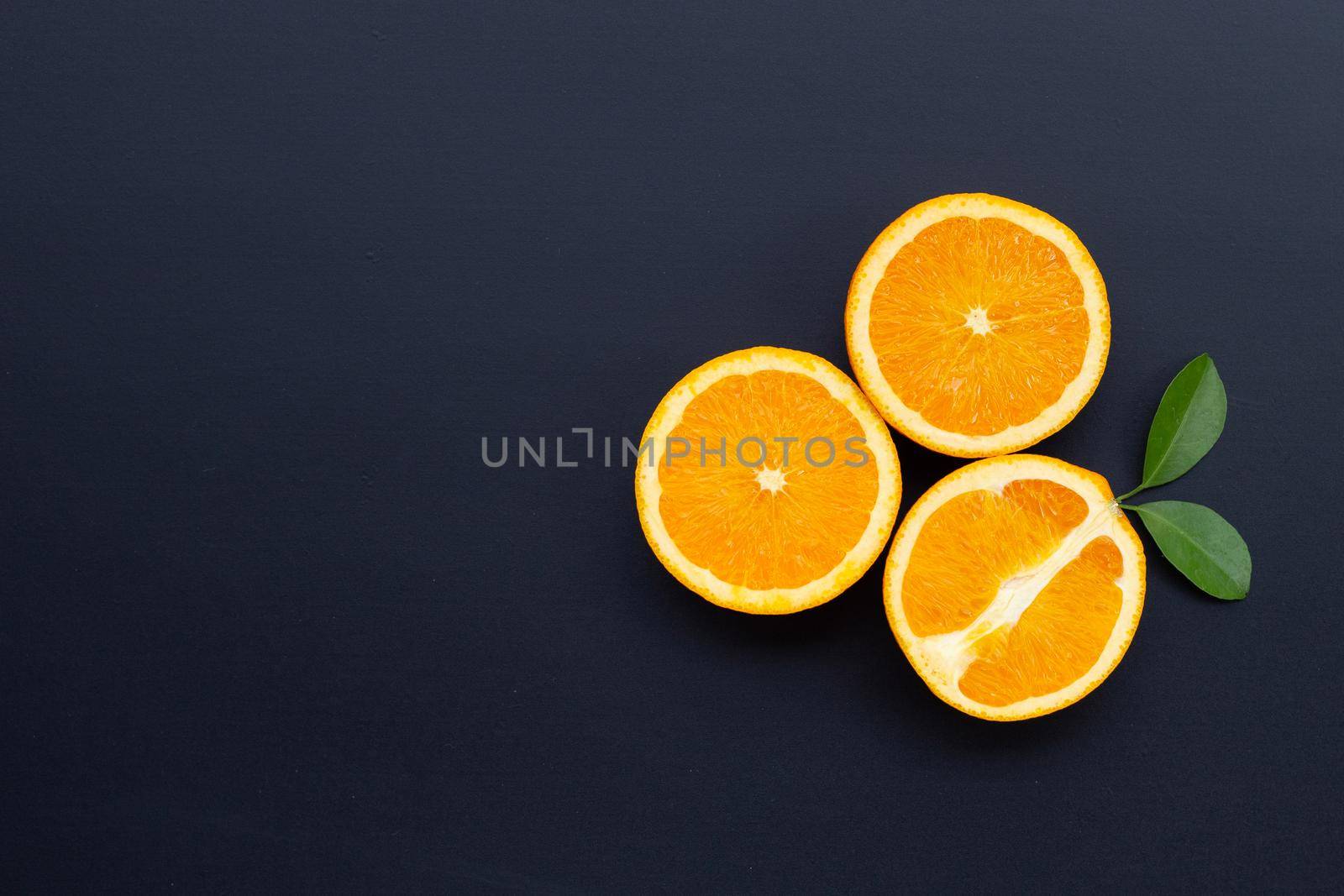 High vitamin C, Juicy and sweet. Fresh orange fruit with green leaves on dark wooden background.