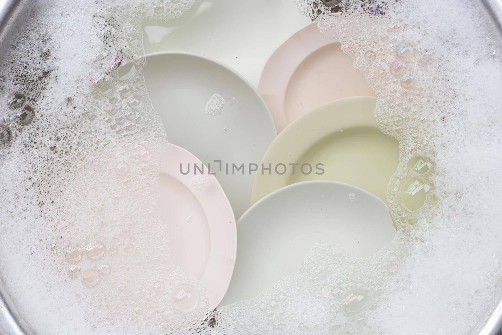 Washing dishes, Close up of utensils soaking in kitchen sink.