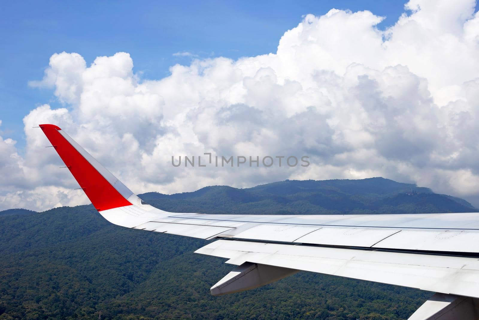 View of mountain, sky, cloud and wing of airplane from window