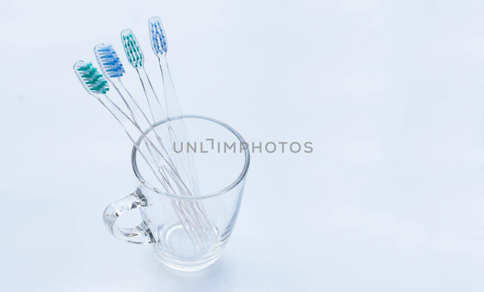 Toothbrushes in a glass on white. Copy space