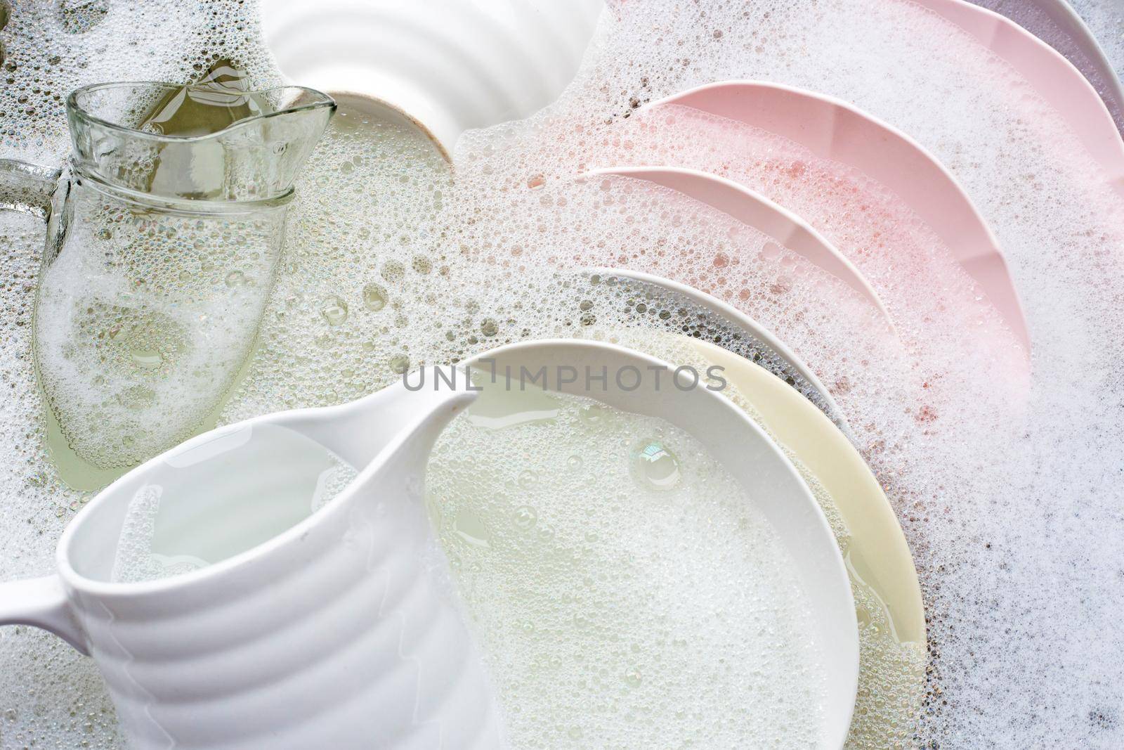 Washing dishes, Close up of utensils soaking in kitchen sink.