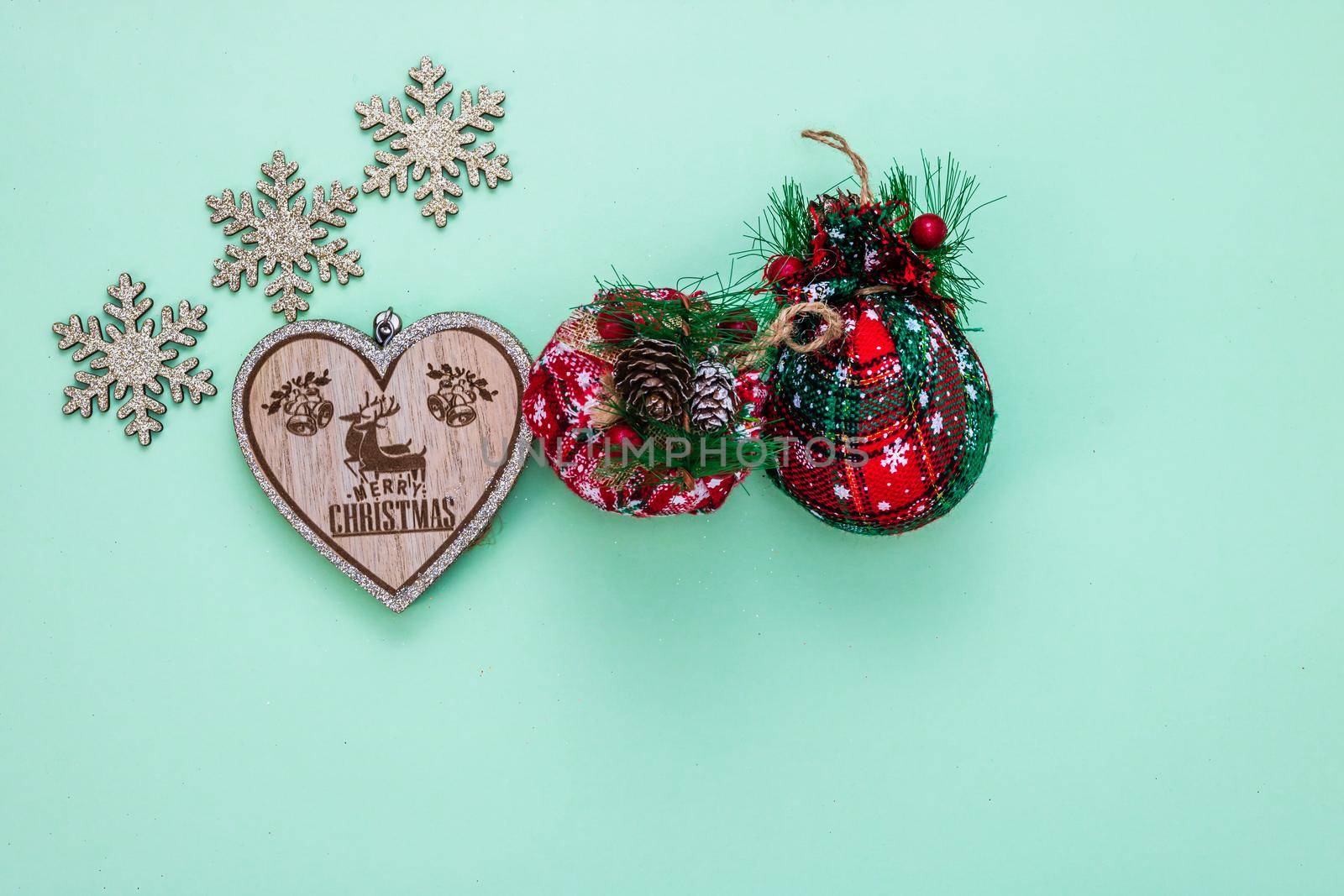 December season composition, top view with copy space on green background. Christmas composition with ornaments and decorations.