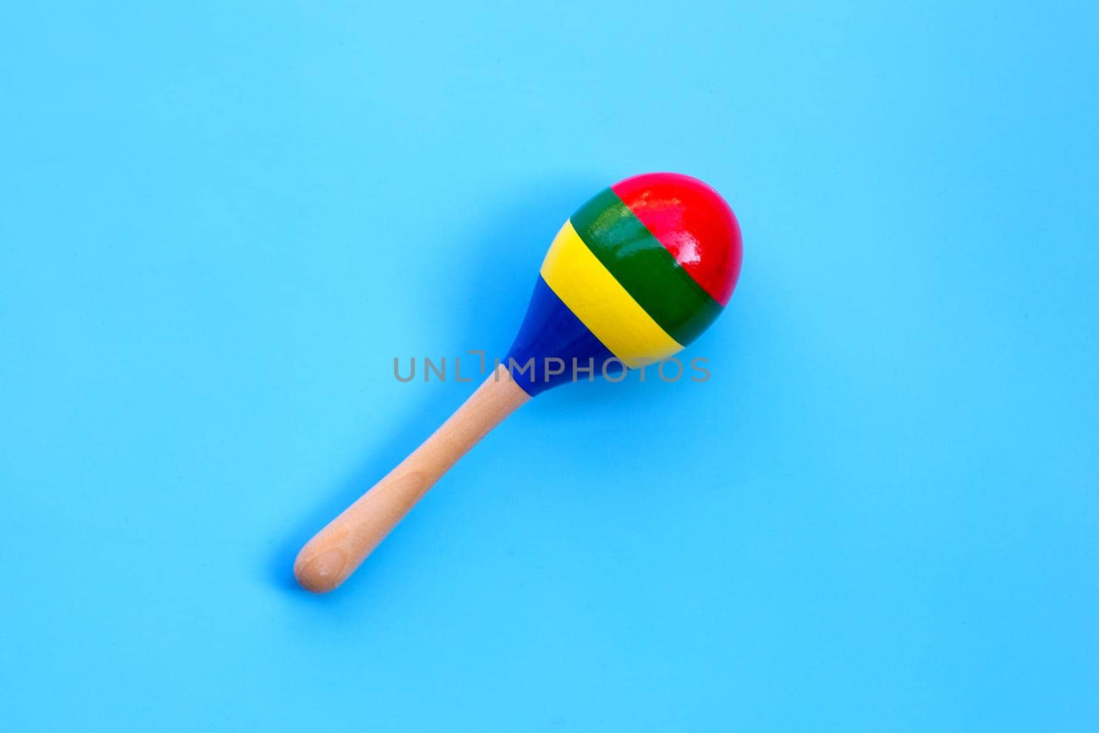Wooden rattle on blue background.