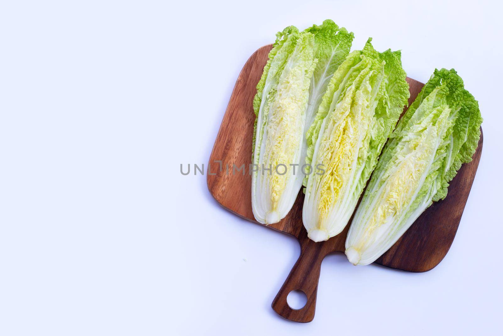 Chinese cabbage on wooden cutting board on white background. Copy space