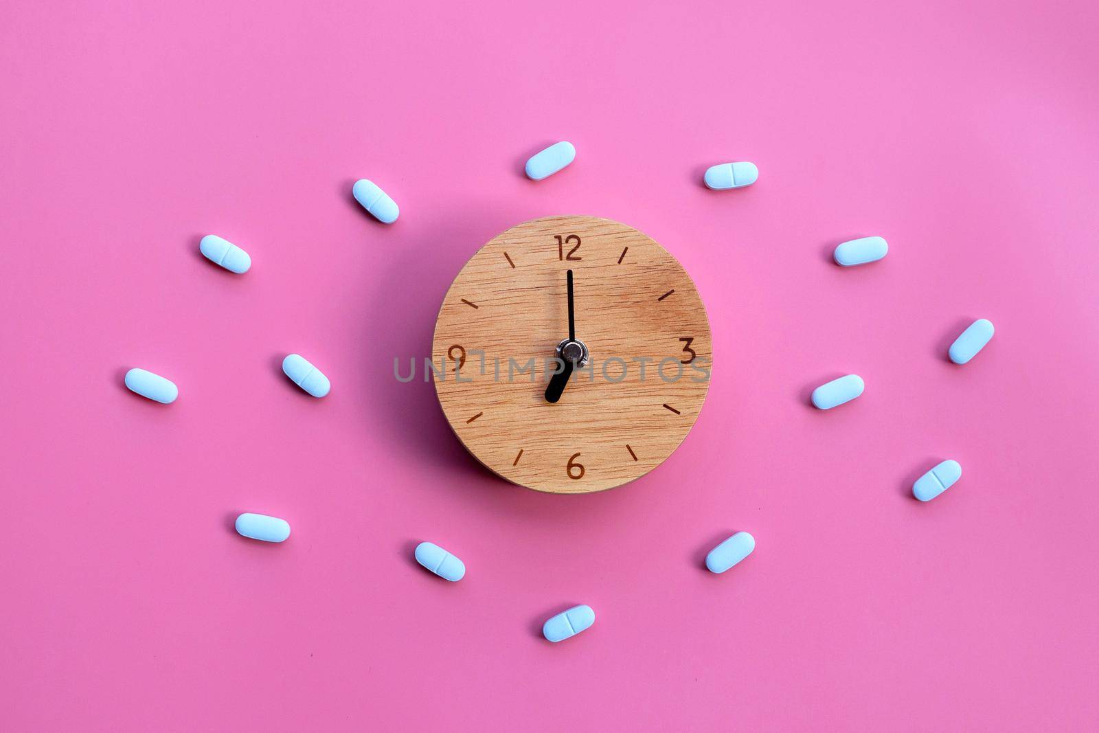 Clock with "PrEP" ( Pre-Exposure Prophylaxis). used to prevent HIV on pink background.