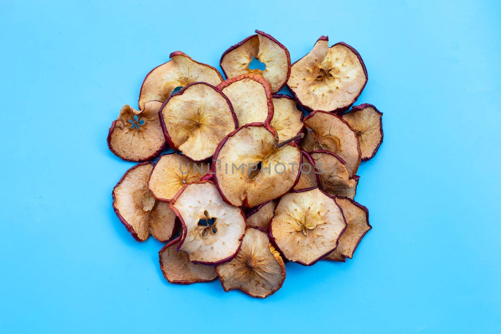 Dried apple slices on blue background