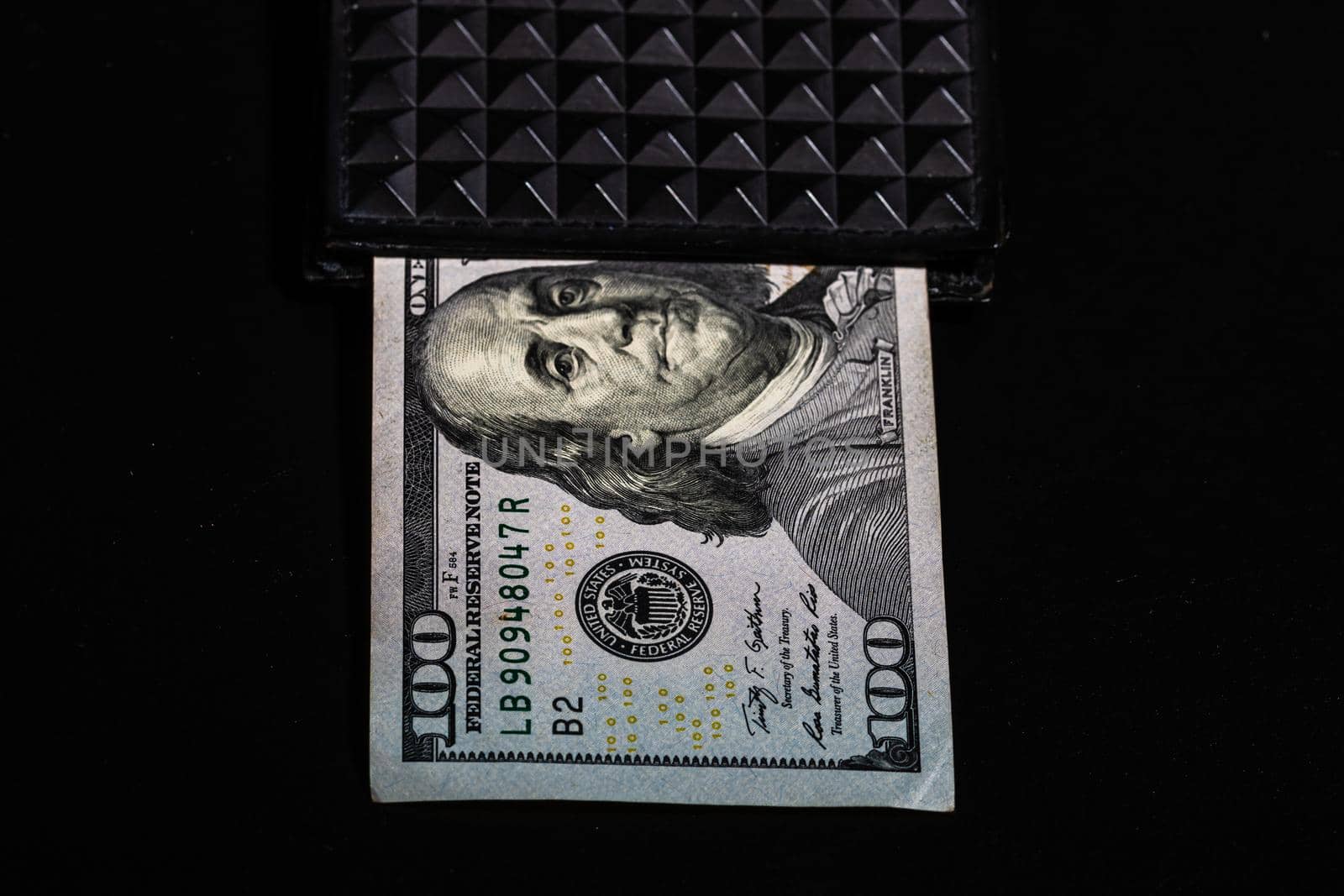 100 Dollars banknotes in a black wallet isolated