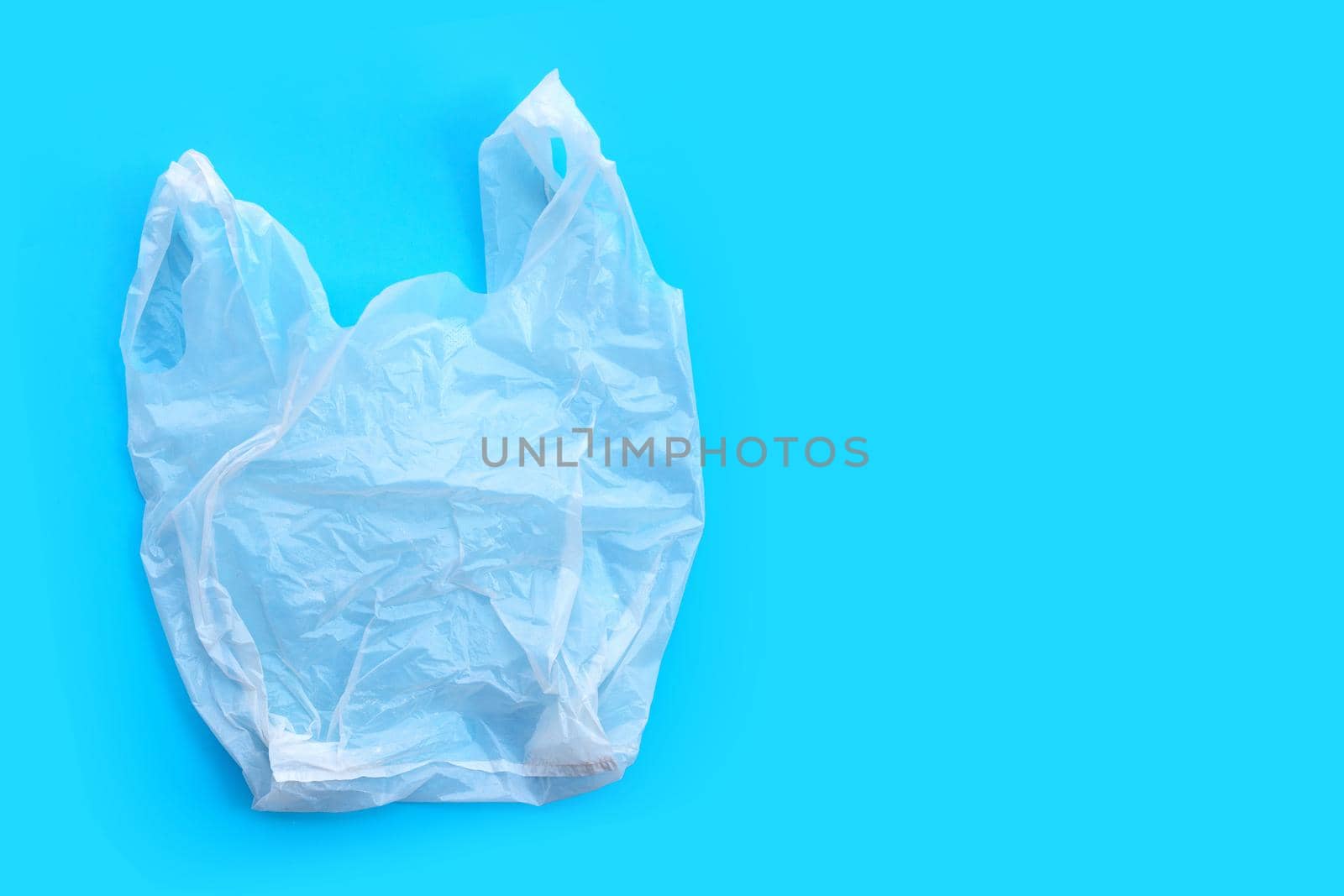 White plastic bag on blue background. Copy space