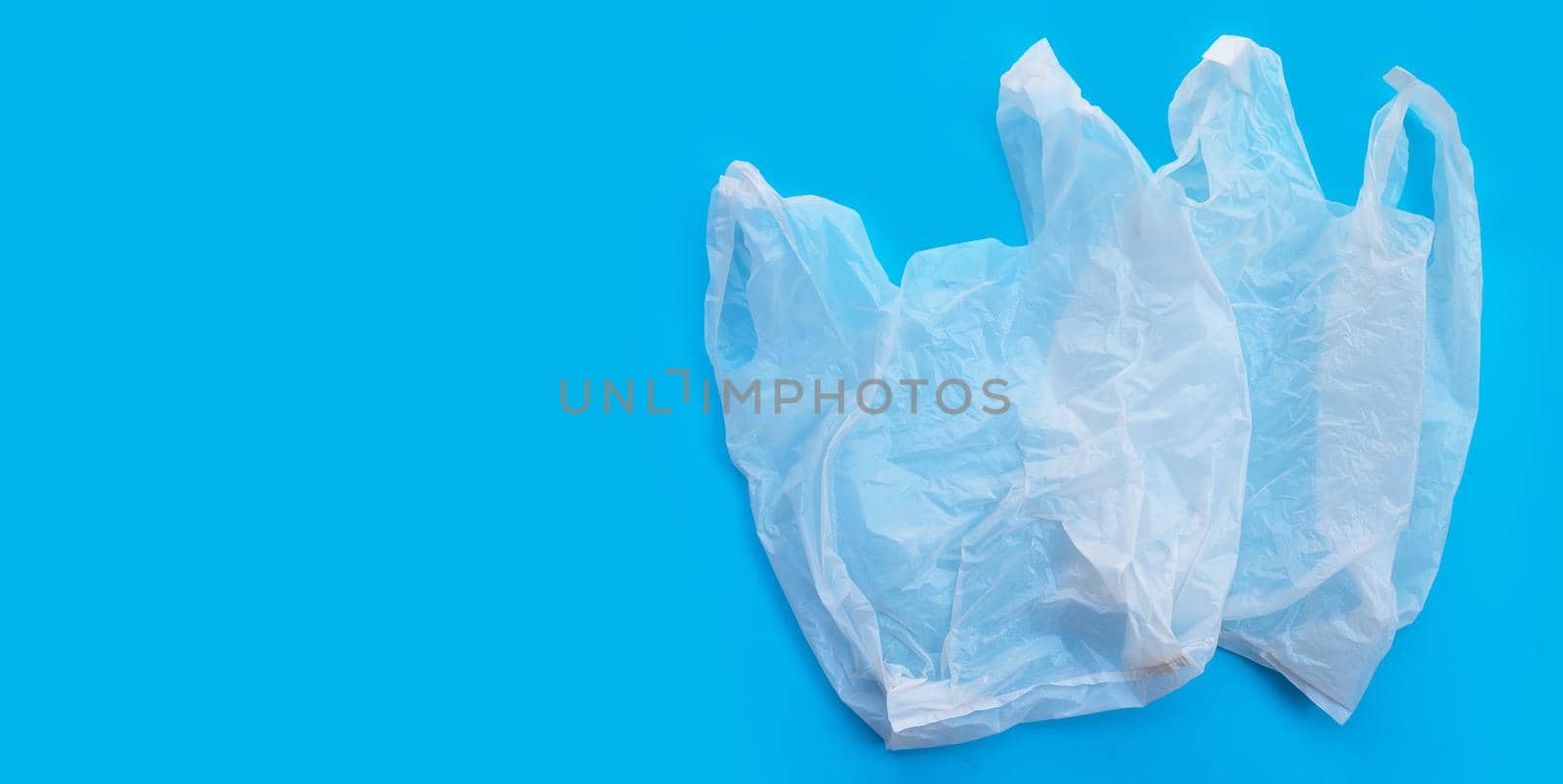 White plastic bags on blue background. Copy space