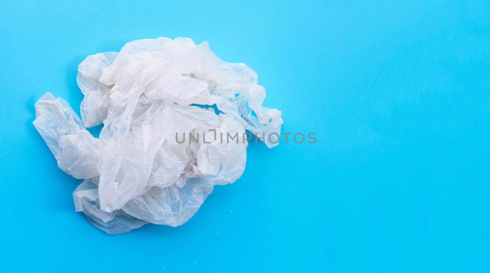 Crumpled plastic bags on blue background. Copy space