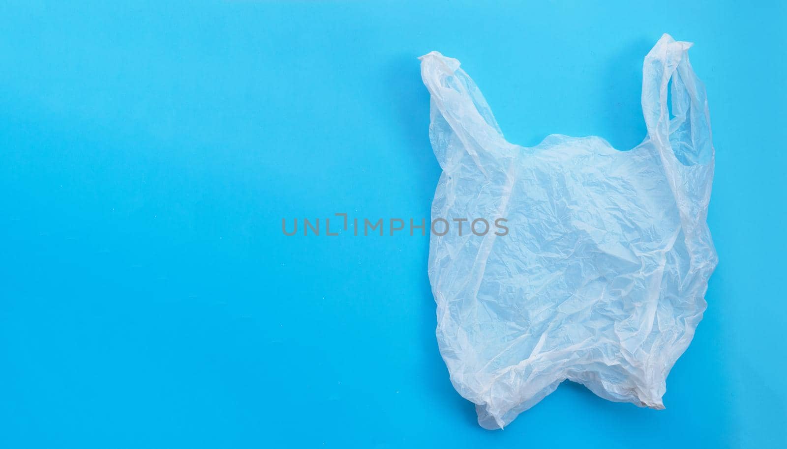 White plastic bag on blue background. Copy space