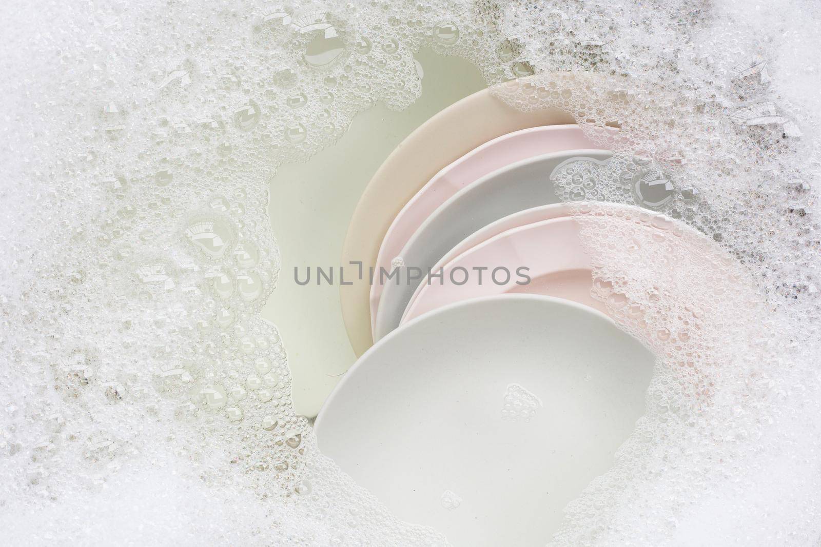 Washing dishes, Close up of utensils soaking in kitchen sink.