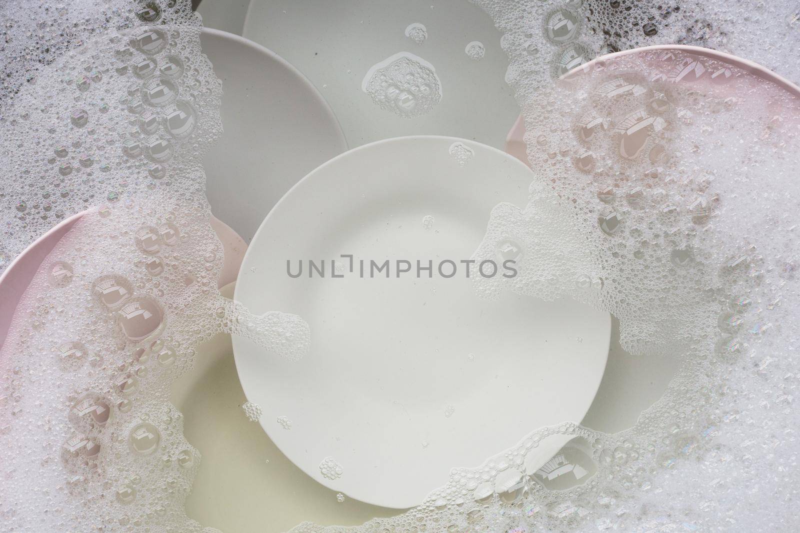 Washing dishes, Close up of utensils soaking in kitchen sink.