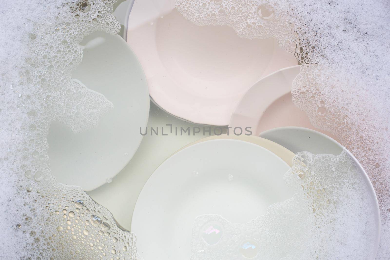 Washing dishes, Close up of utensils soaking in kitchen sink.