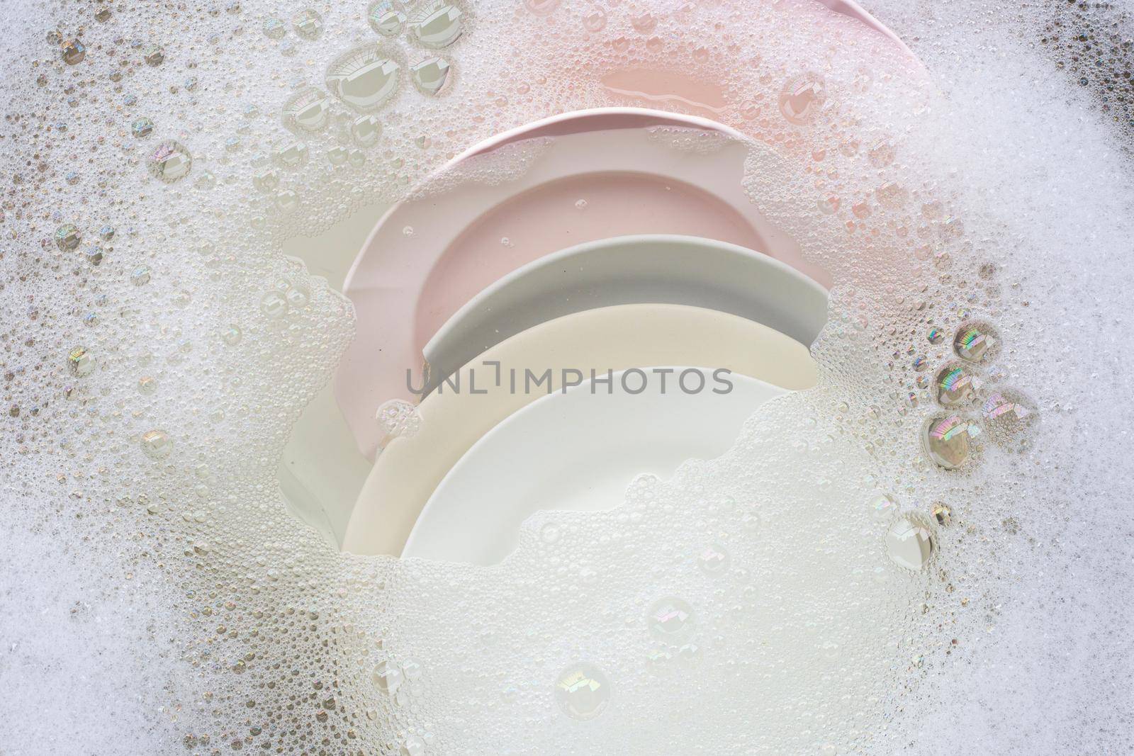 Washing dishes, Close up of utensils soaking in kitchen sink. by Bowonpat