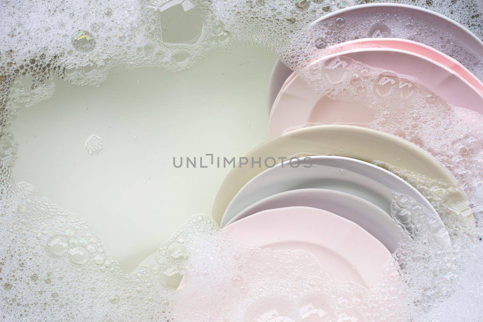 Washing dishes, Close up of utensils soaking in kitchen sink.