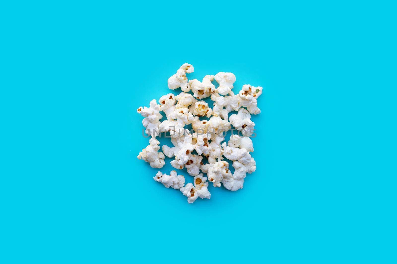 Popcorn on blue background. Copy space