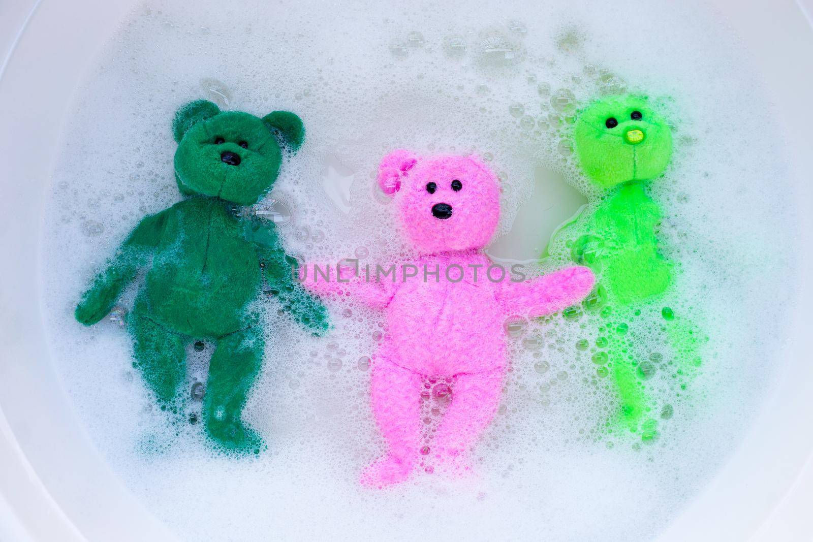 Soak toy bears in laundry detergent water dissolution before washing.  Laundry concept, Top view