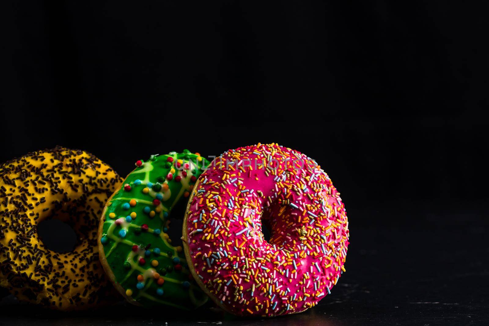 Glazed donuts with sprinkles isolated. Close up of colorful donuts.