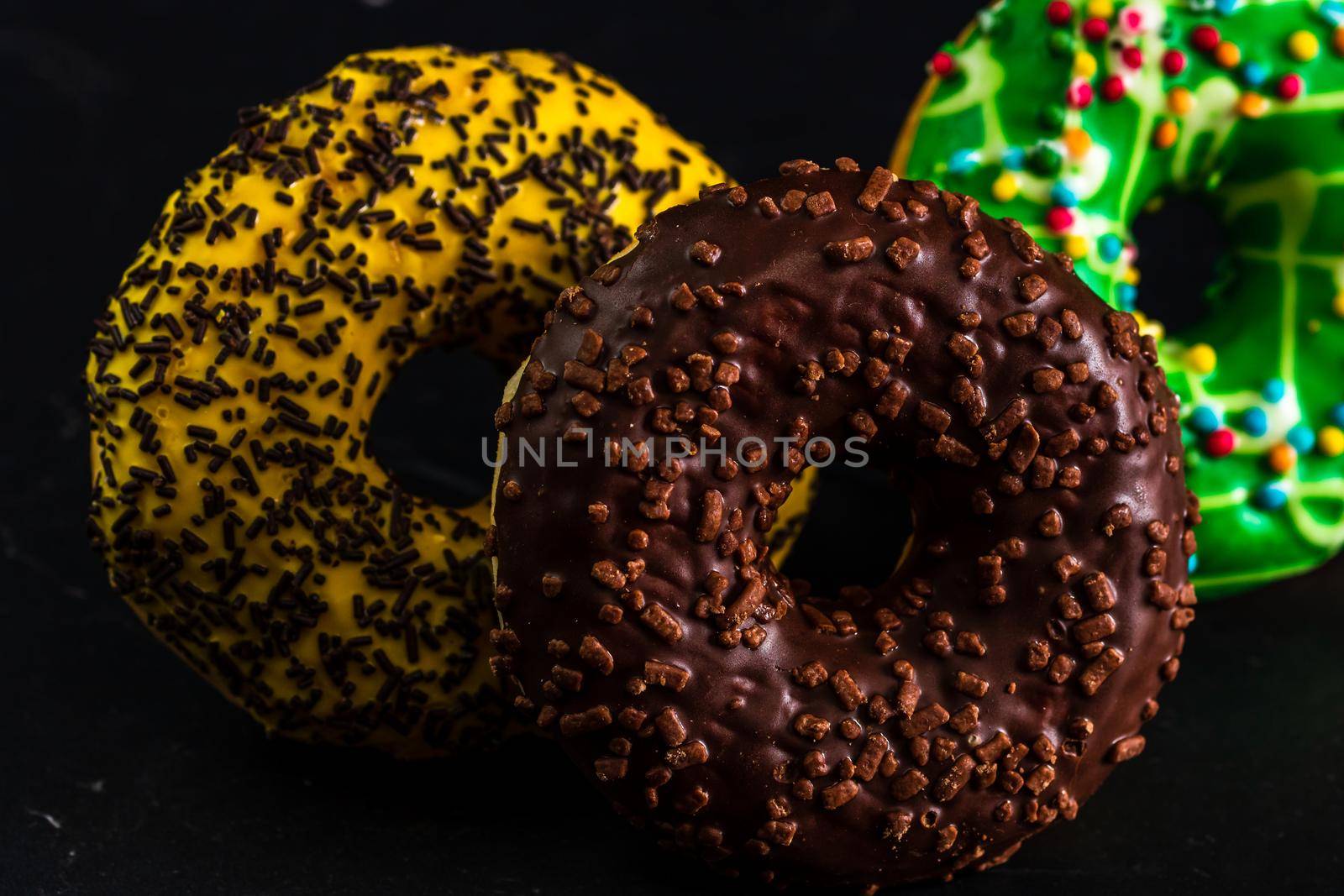 Glazed donuts with sprinkles isolated. Close up of colorful donuts.