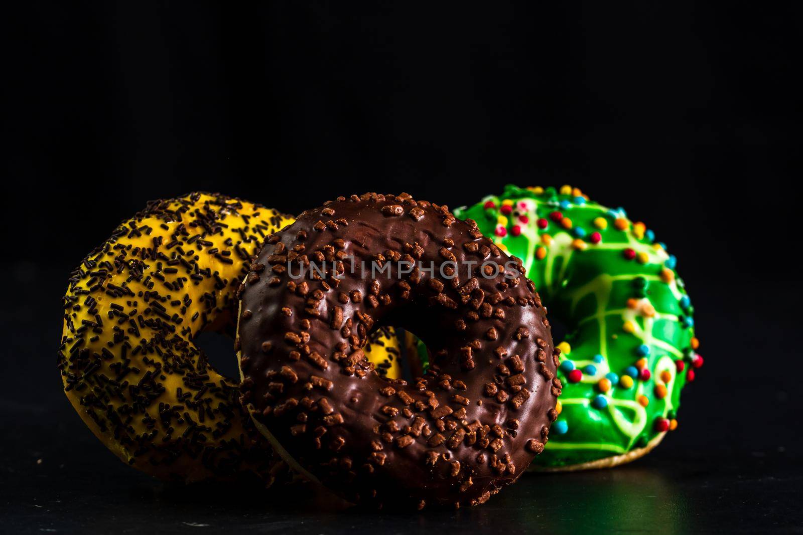 Glazed donuts with sprinkles isolated. Close up of colorful donuts.