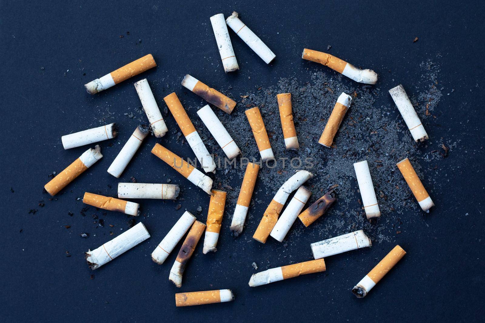 Cigarette butts on dark background.