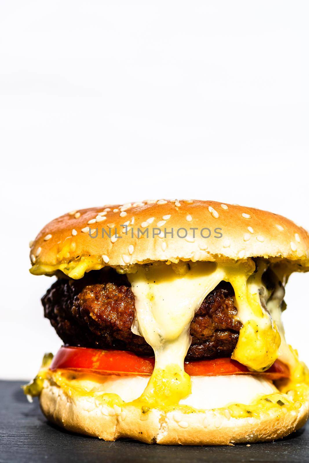 Beef cheeseburger with melting cheese. Tasty homemade cheeseburger isolated on white background.