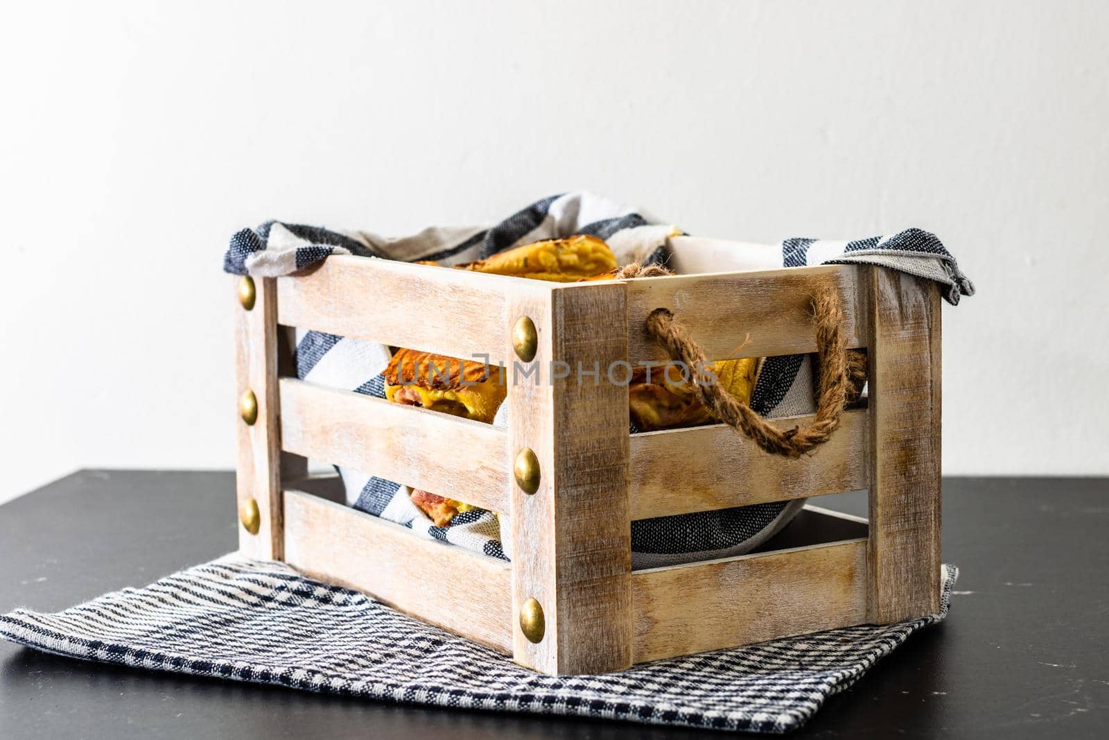 Freshly baked homemade ham and cheese puff pastry in a rustic crate.