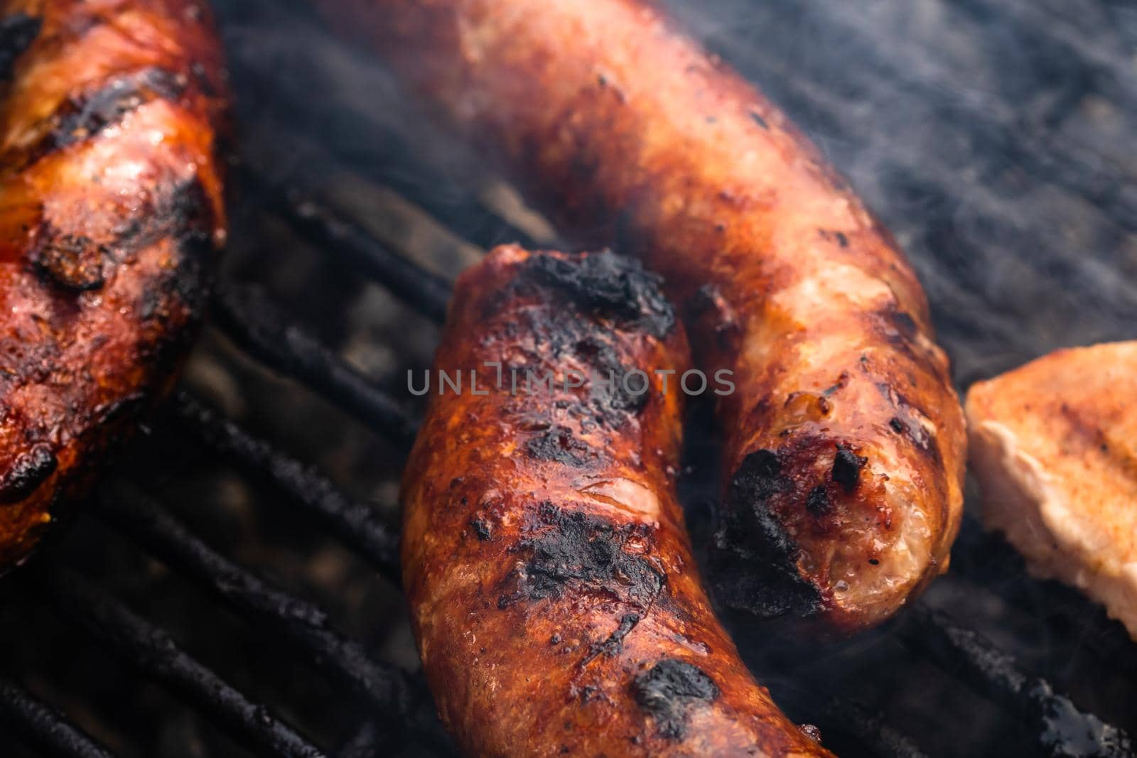 Close up on details of homemade sausages on barbecue grill. Barbecue, grill and food concept.