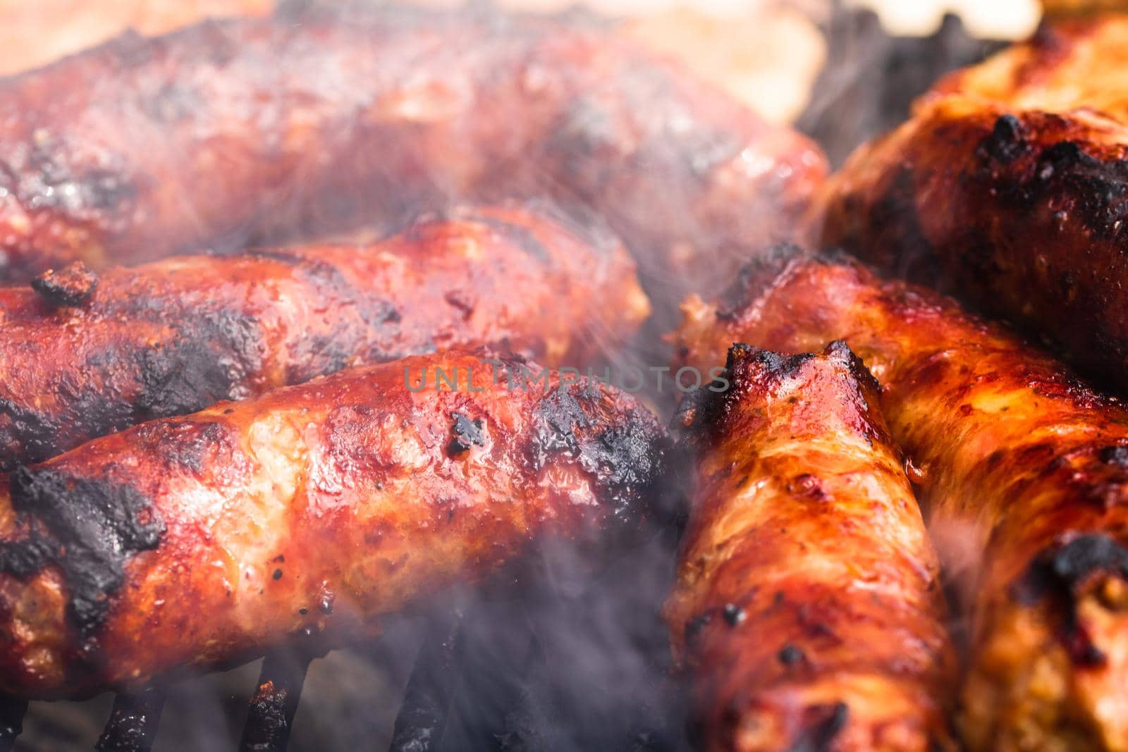 Close up on details of homemade sausages on barbecue grill. Barbecue, grill and food concept.