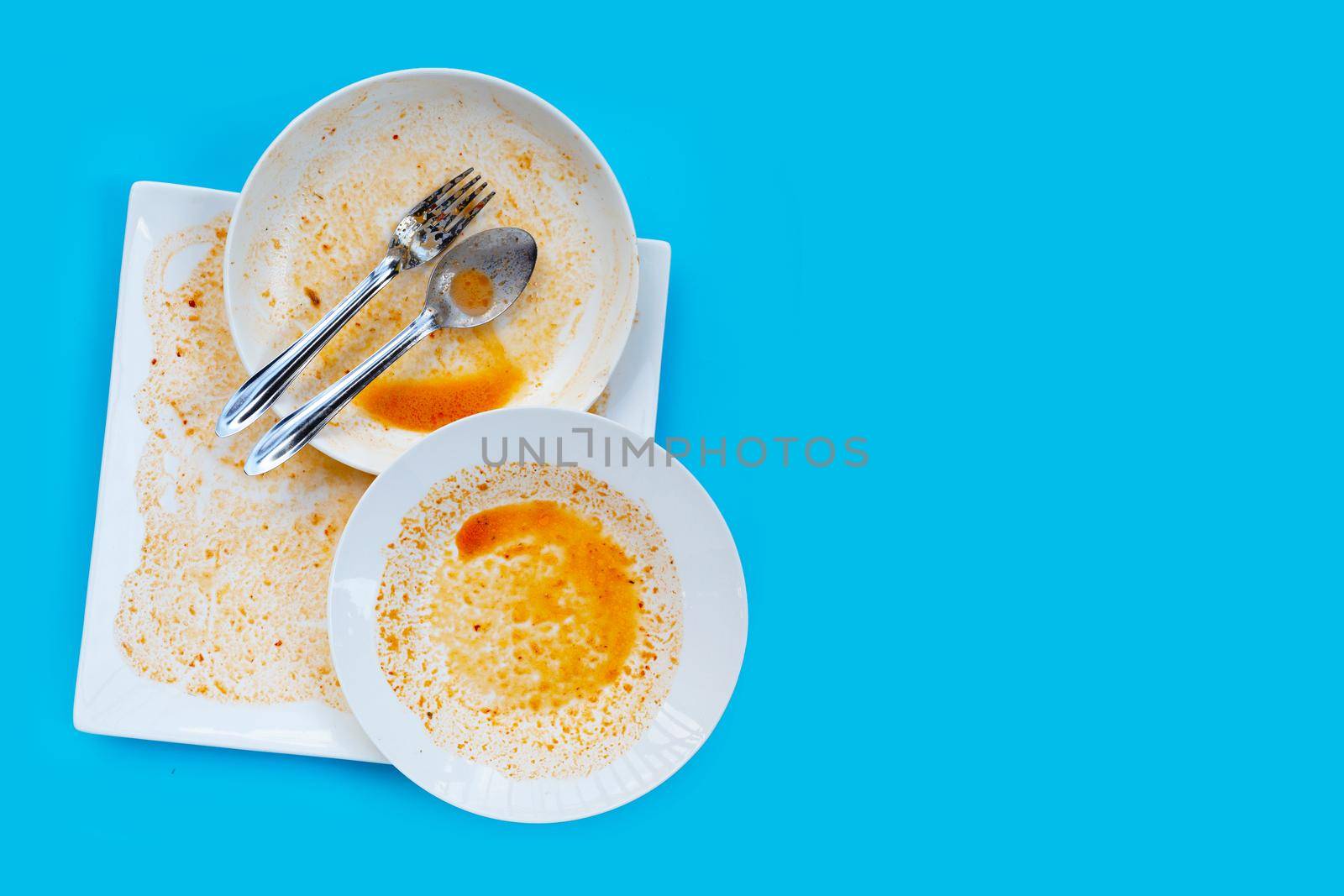 Dirty dishes on blue  background. Top view by Bowonpat