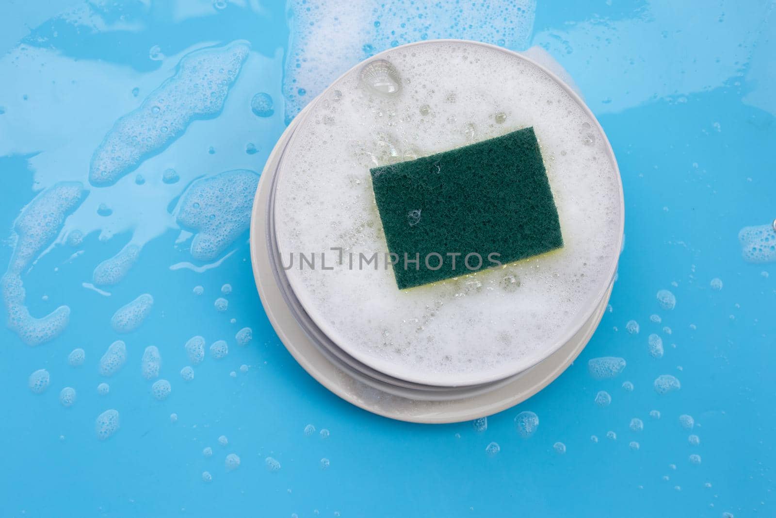 Washing dishes concept on wet blue background. Top view