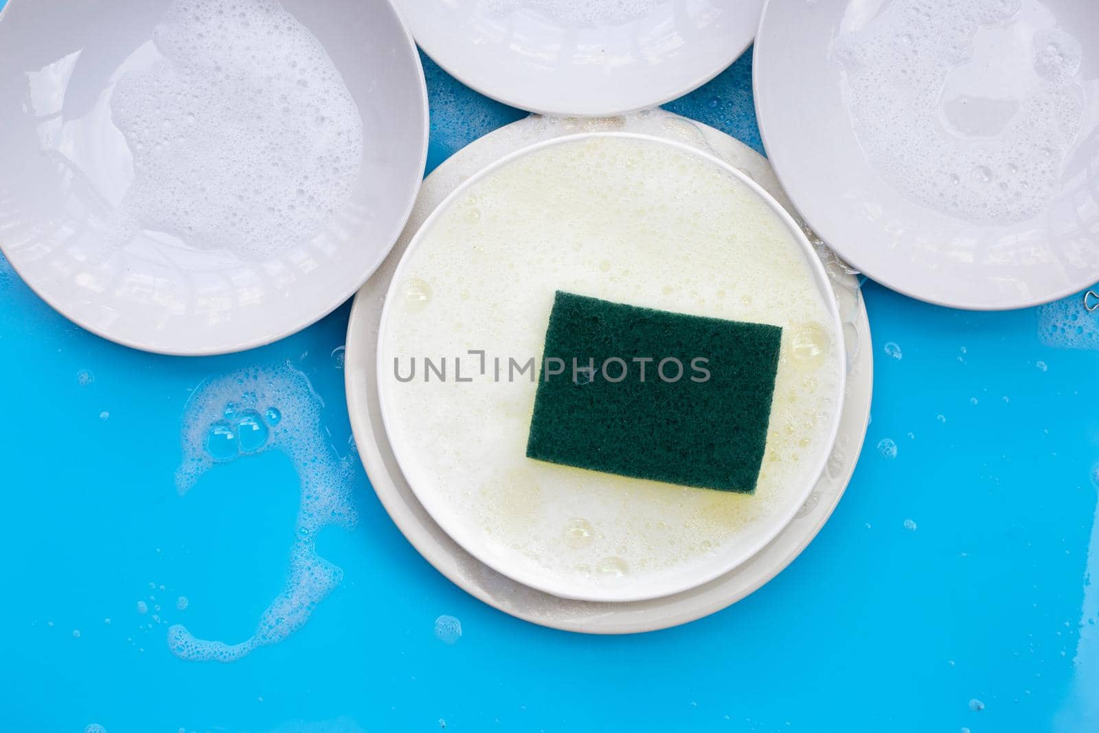 Washing dishes concept on wet blue background. Top view