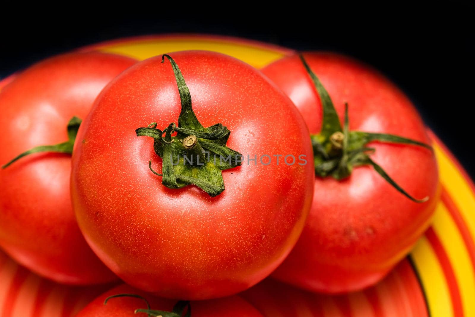 Close up of ripe red tomato, tomatoes background.